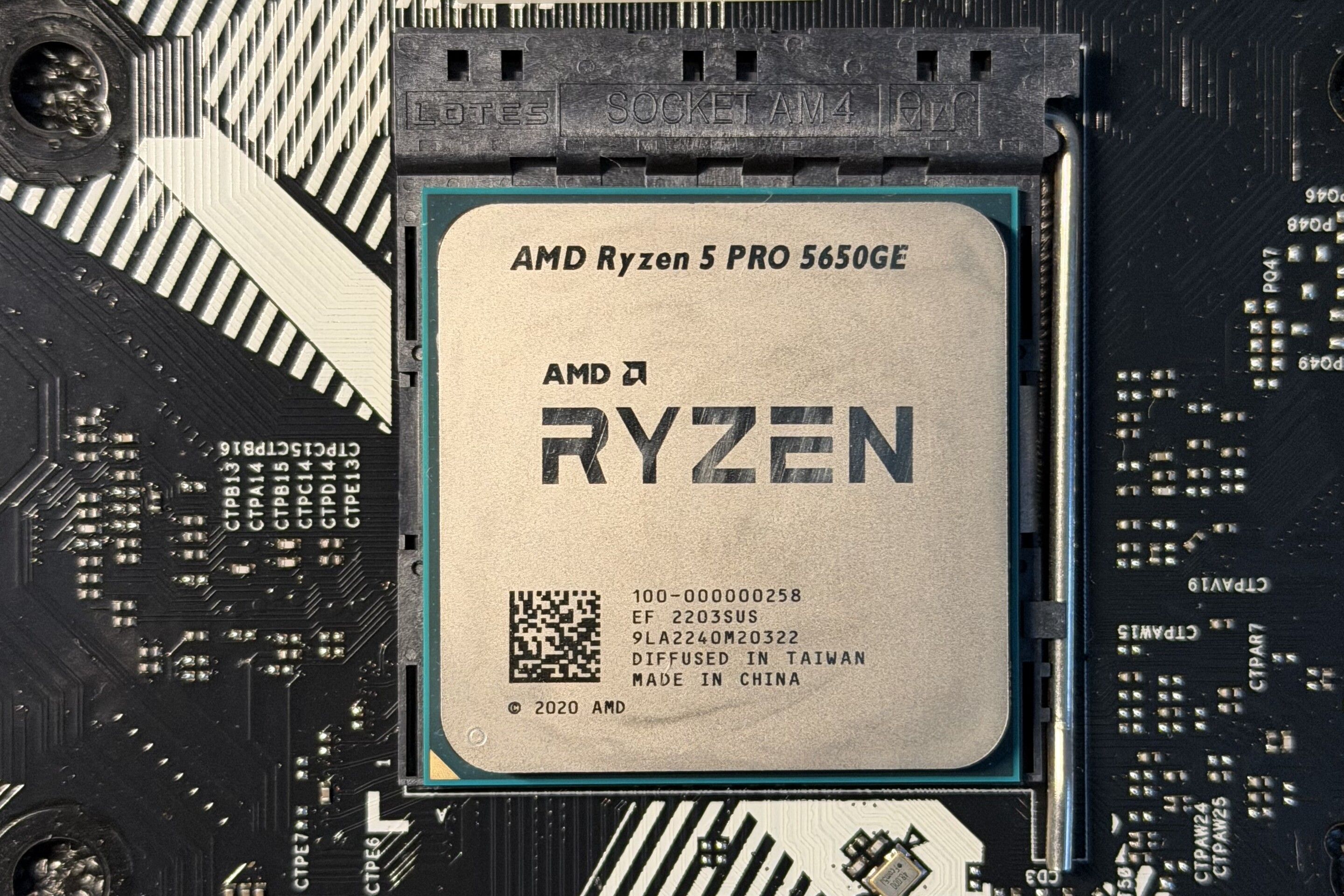 Close-up of an AMD Ryzen 5 PRO 5650GE installed in the AM4 socket of an ASRock B550M Pro4 motherboard.