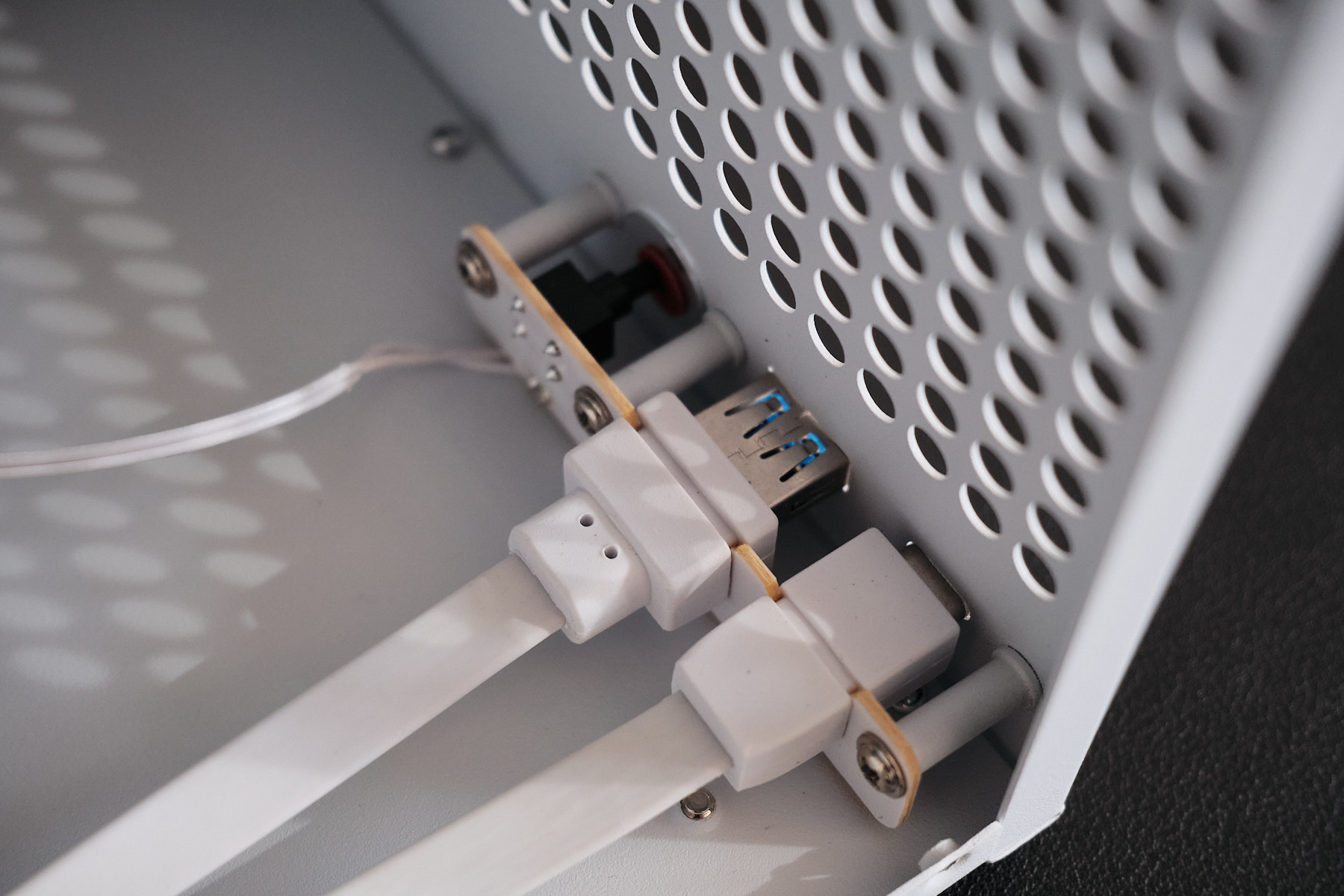 Internal view of the front panel showing USB 3.0 header cables and the power button wire connected behind the perforated front panel